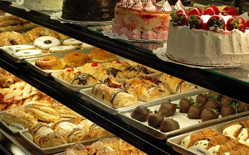Trays of danish, chocolate-drizzled pastries, chocolate-dipped strawberries and cannoli in the Lancers Diner bakery case